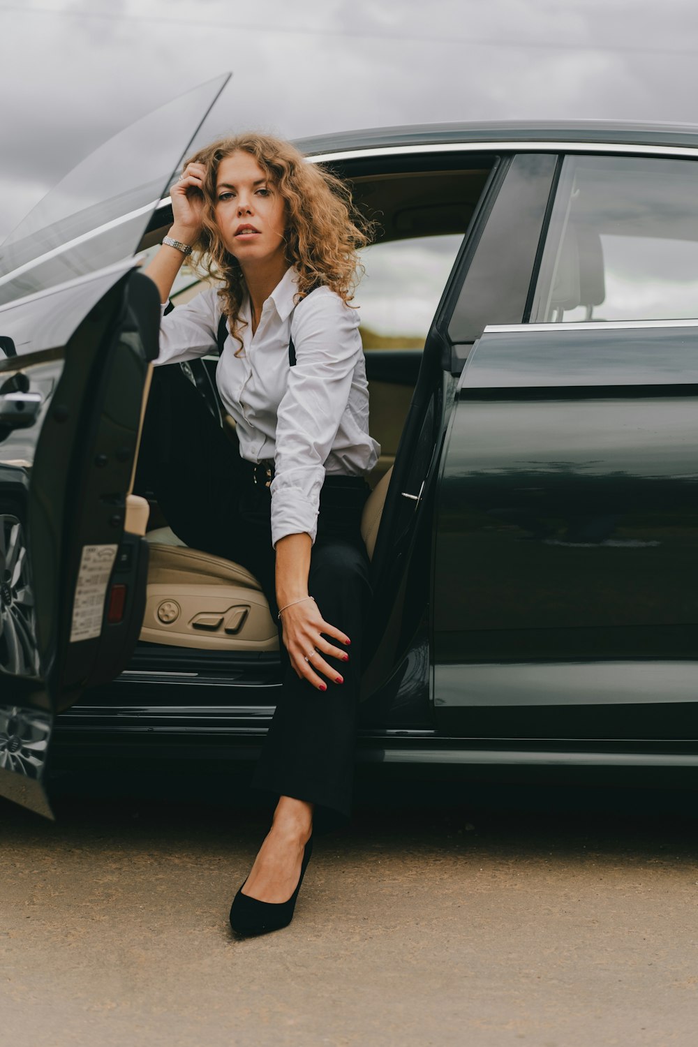 a woman sitting in the open door of a car