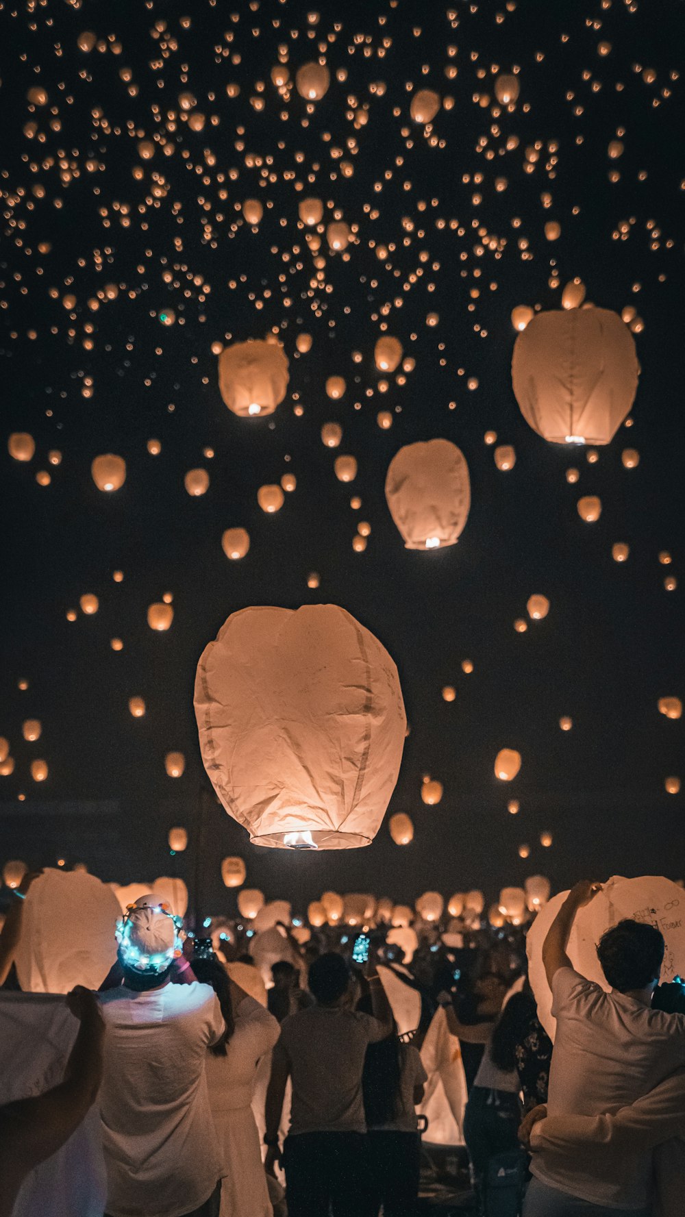 Un gruppo di persone che volano lanterne di carta nel cielo foto – Uomo  Immagine gratuita su Unsplash