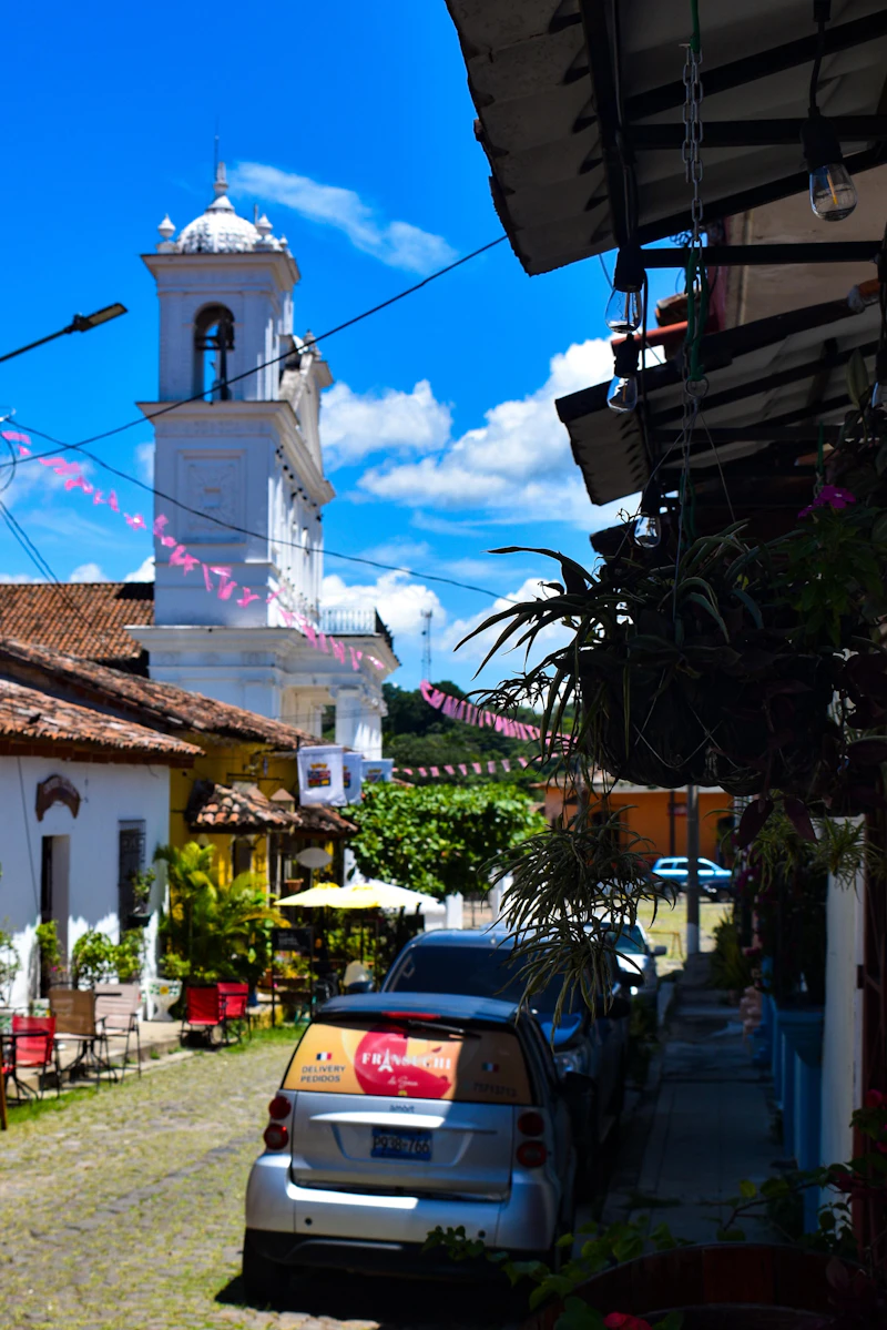 A cobblestone street leading to a colonial church