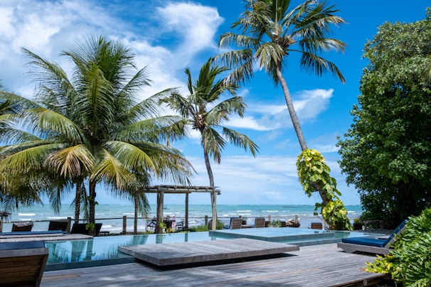 A serene beachfront property in Ashvem with palm trees swaying under a clear blue sky.