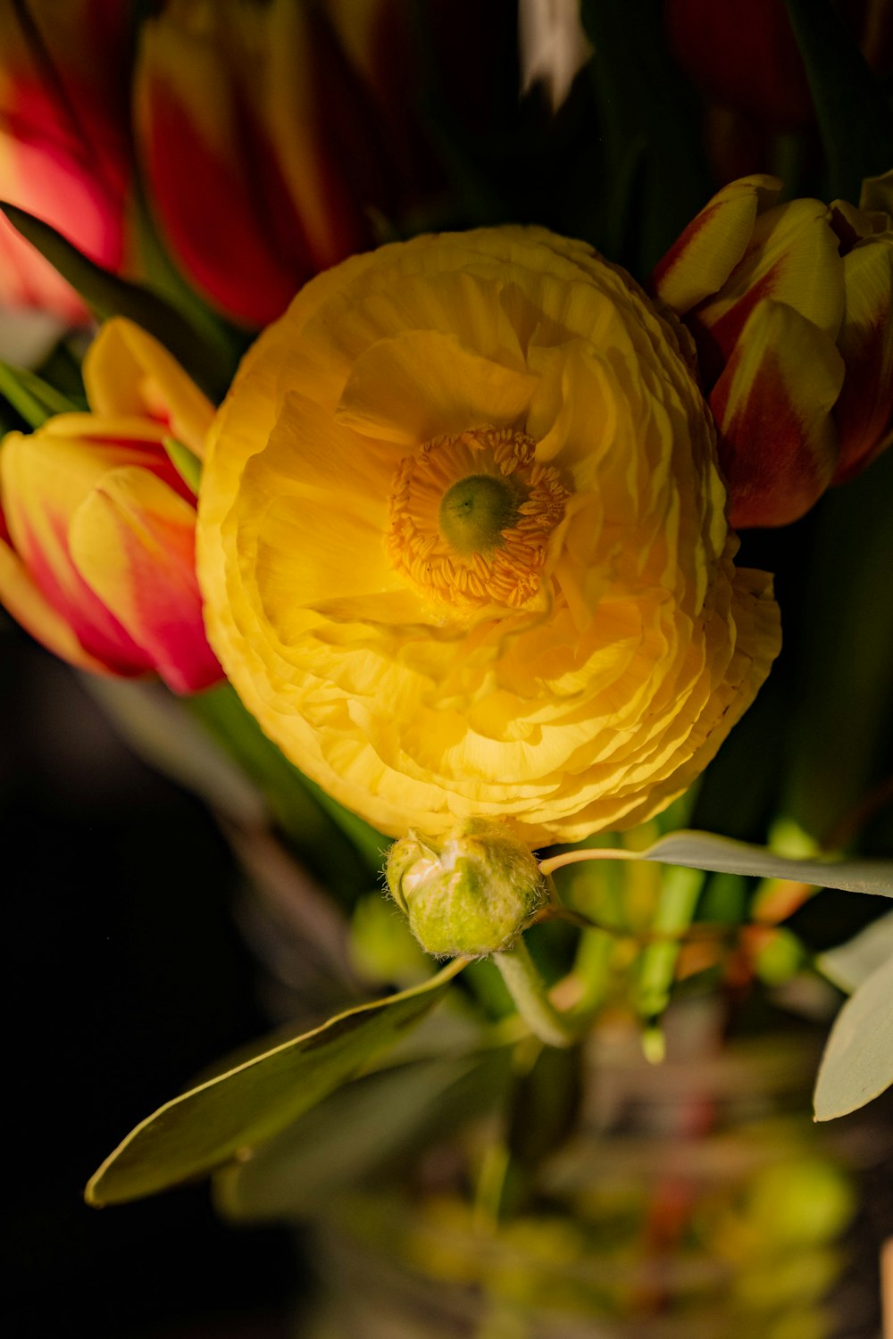 a vase filled with yellow and red flowers