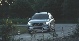 a silver volvo suv driving down a road