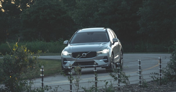 a silver volvo suv driving down a road