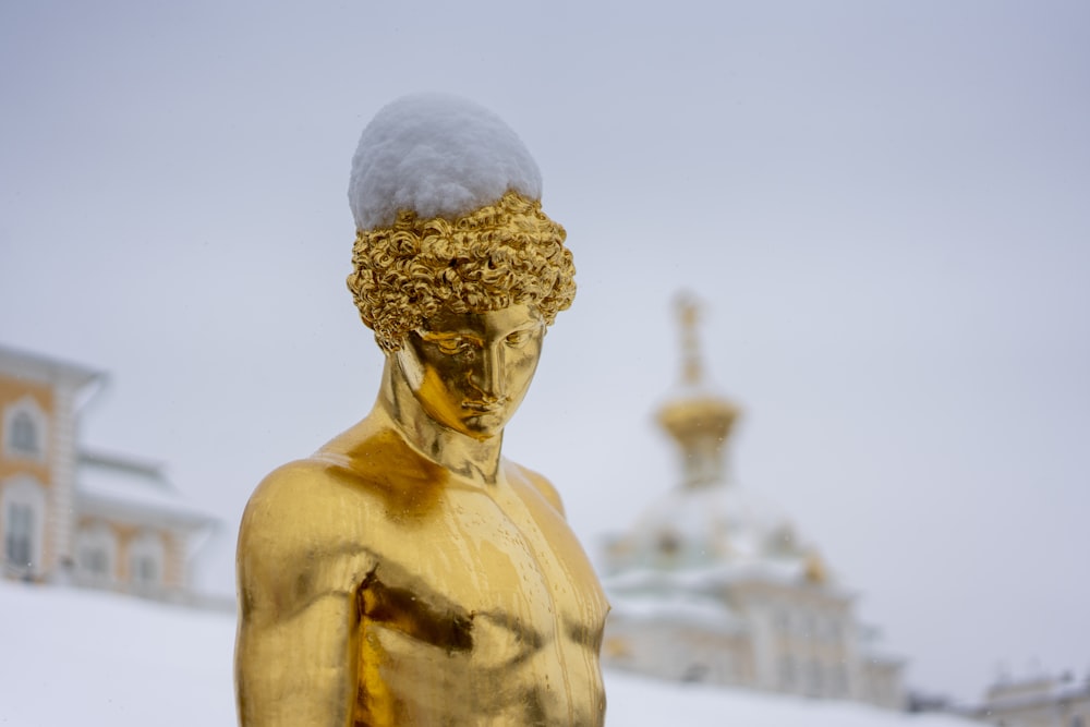 a gold statue with a white hat on top of it