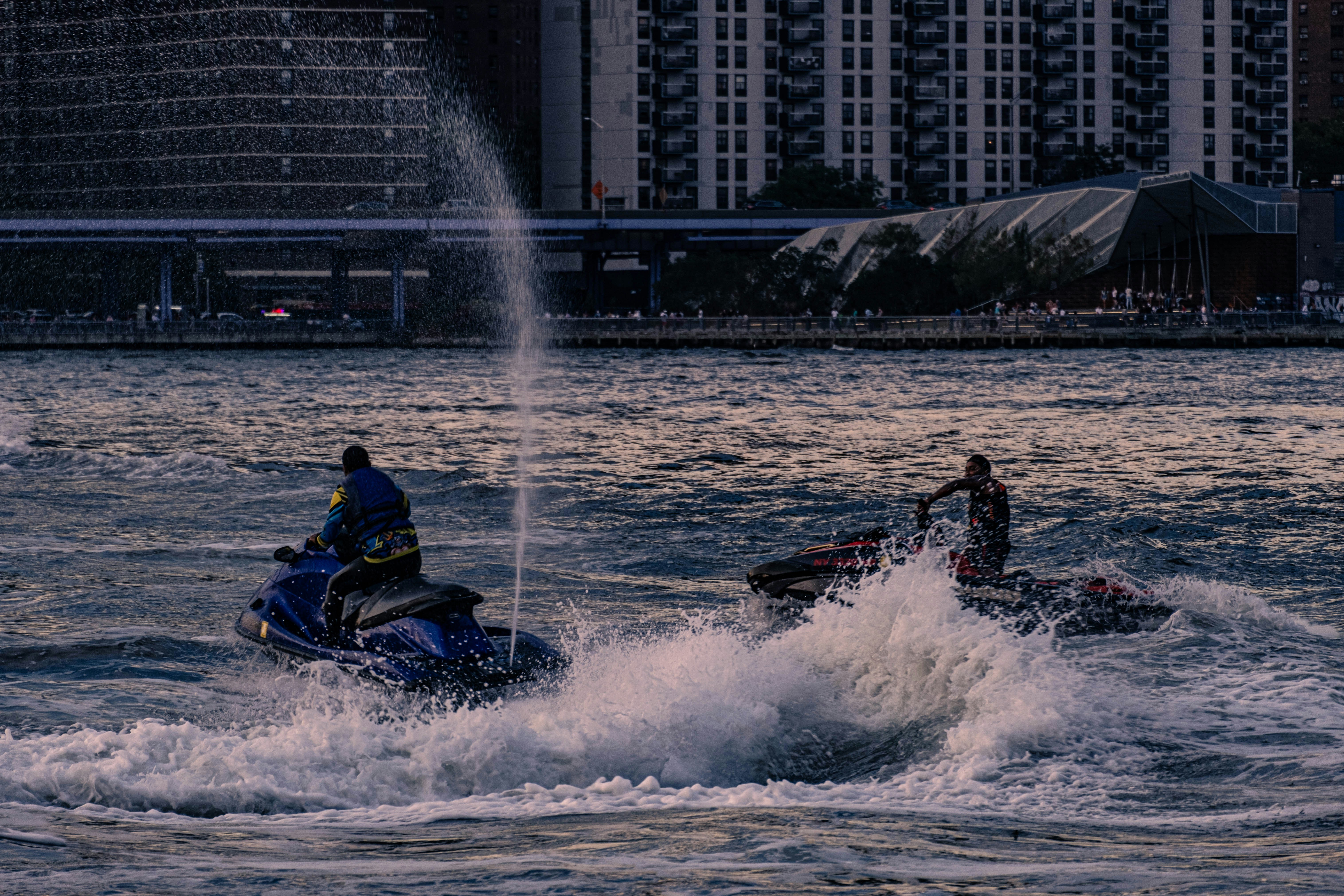 two people riding jet skis on a body of water