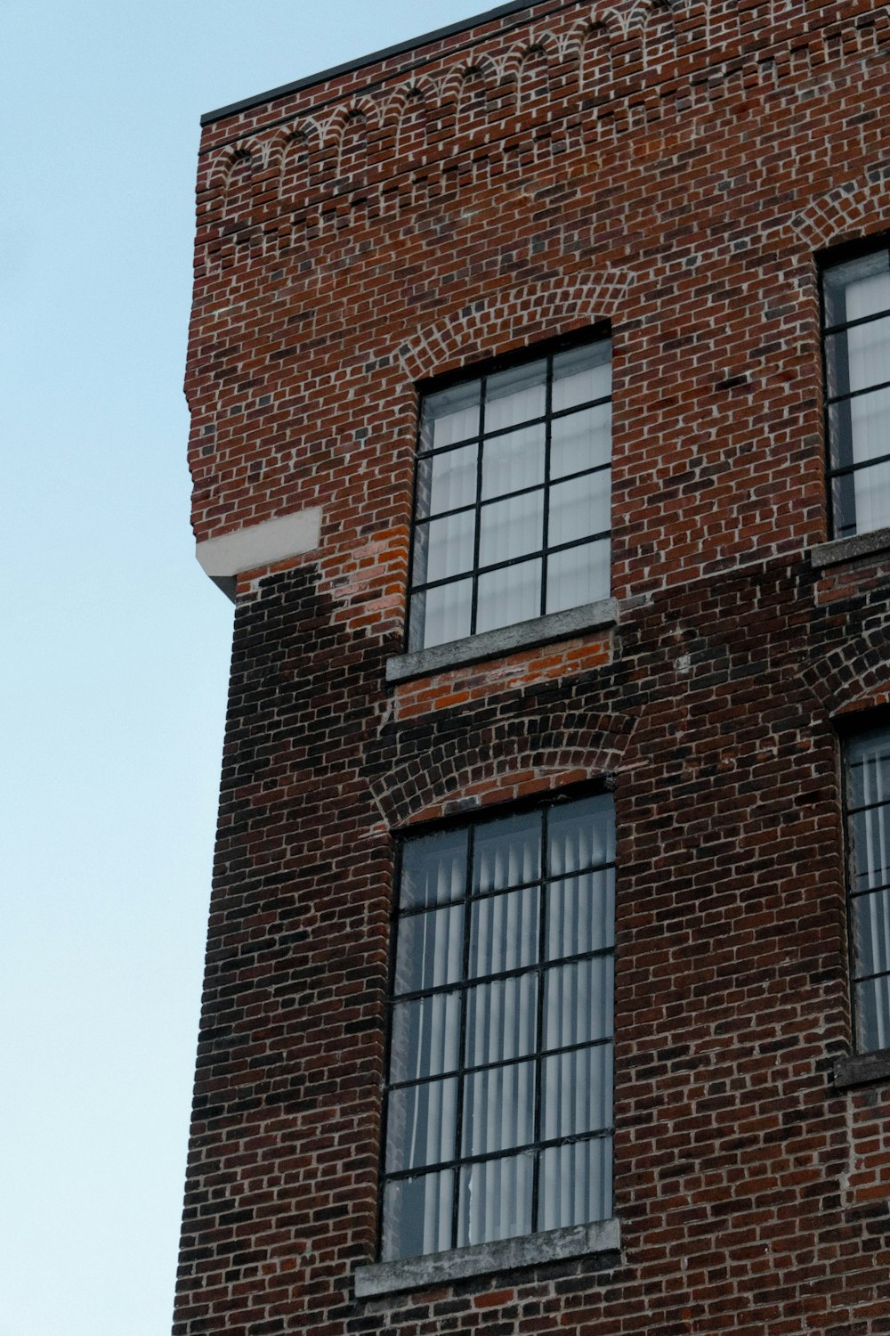 세 개의 창문과 시계가있는 벽돌 건물