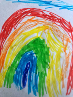 A colorful drawing of a smiling sun and fluffy clouds by a child