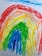 A cheerful child holding a colorful rainbow drawing in a bright classroom.