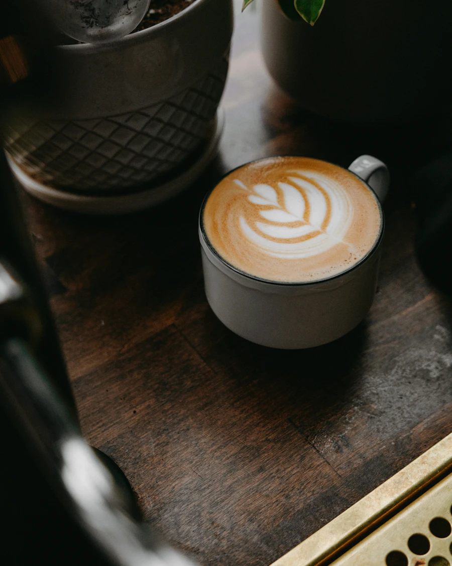 Cappuccino mit Latte Art auf hellem Holztresen