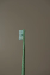 a green toothbrush sitting on top of a table