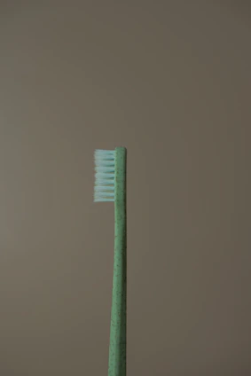 a green toothbrush sitting on top of a table