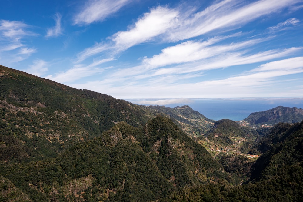 a scenic view of a mountain range with a body of water in the distance