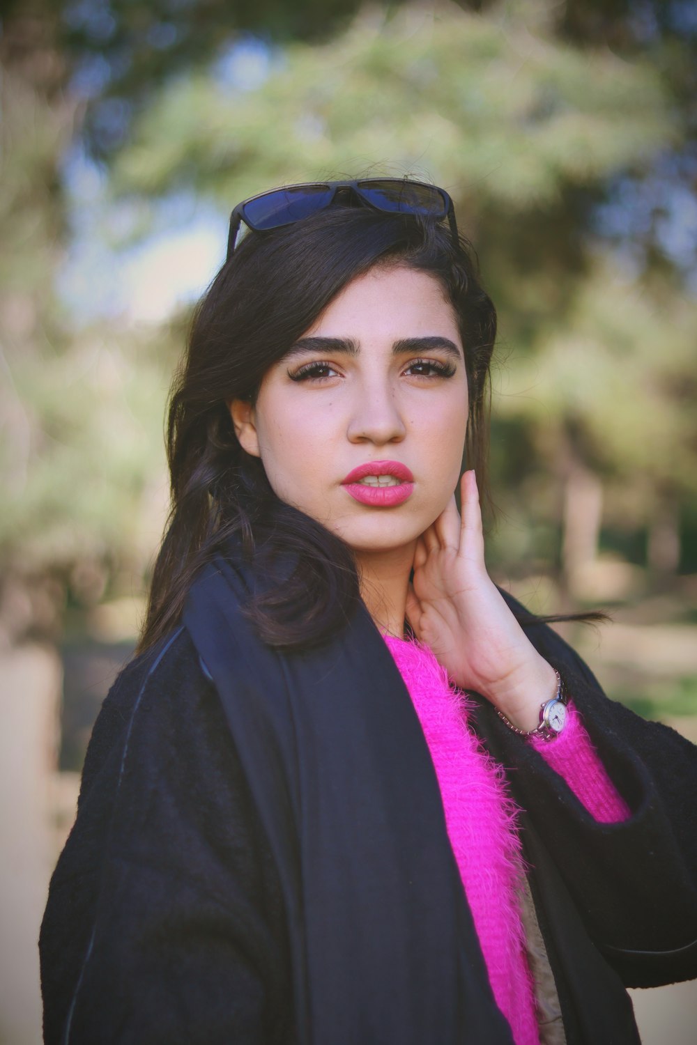 a woman in a black jacket and pink scarf