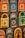 Colorful decorative items resembling miniature window frames are displayed. Each piece is intricately designed with various patterns, featuring bold colors like orange, blue, yellow, and green. Some have small wooden doors with detailed carvings and floral motifs.