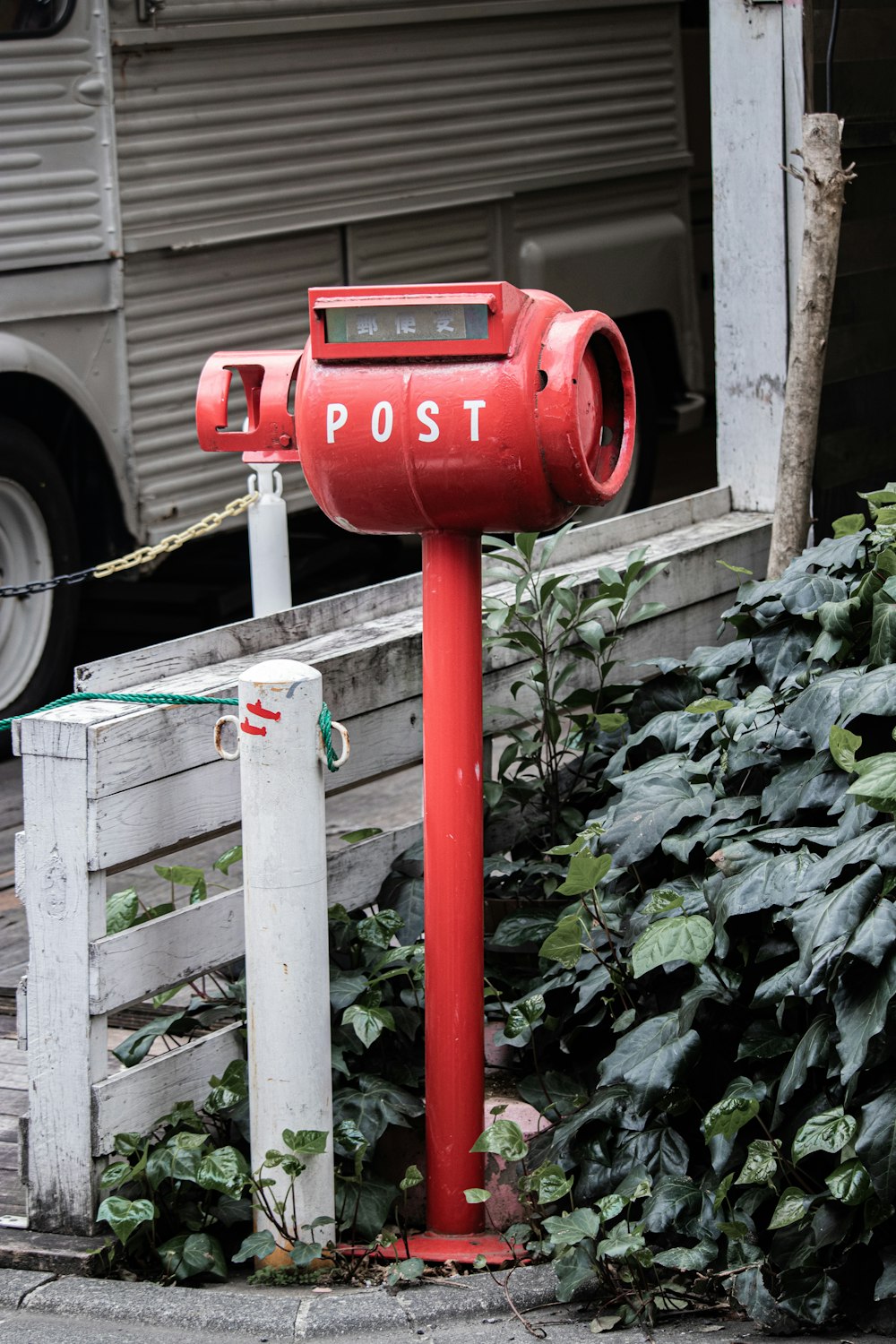 a red post with a mailbox attached to it