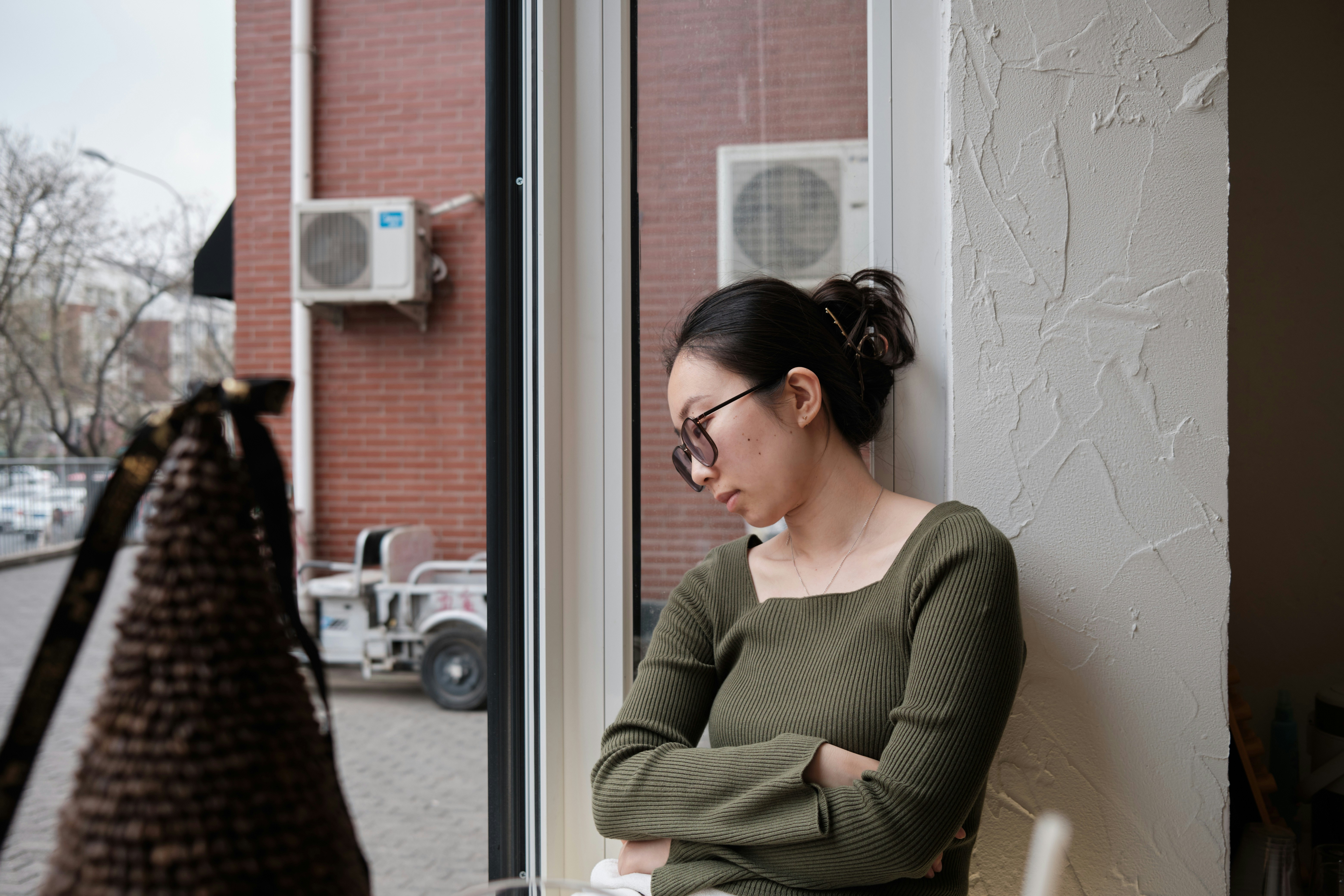 a woman sitting in a chair looking out a window