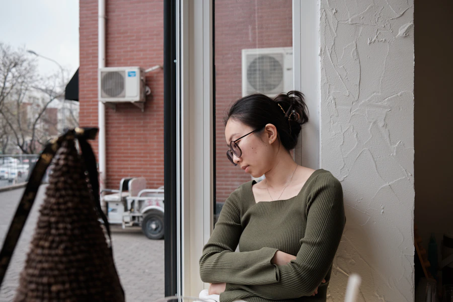 A woman sitting quietly by a window, deep in thought