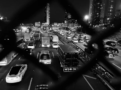 Close-up of a tow truck driver securing a car with chains on a busy highway.