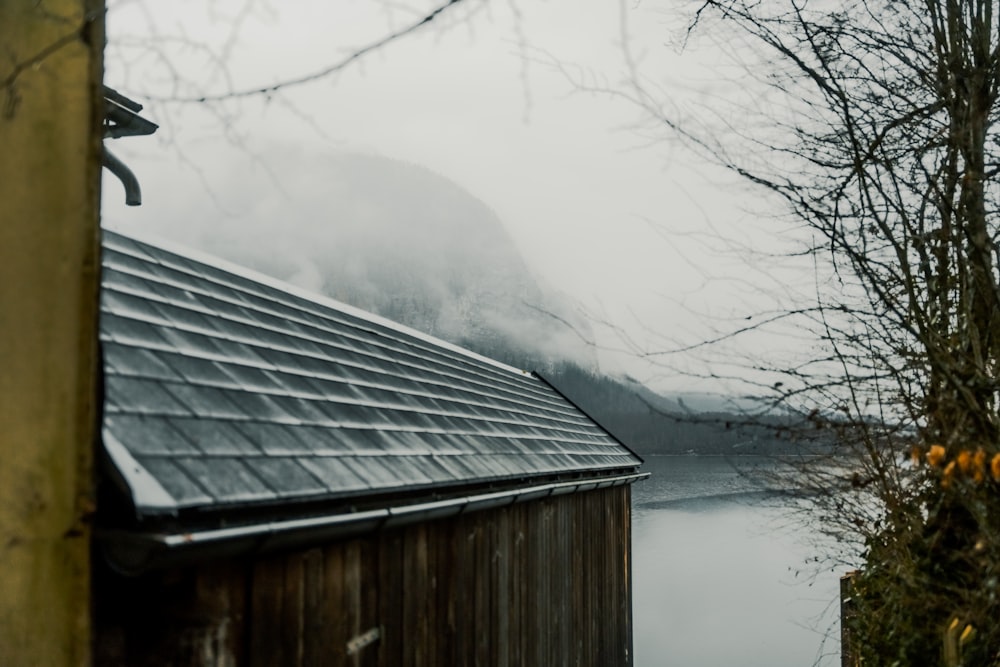 a house next to a body of water on a foggy day