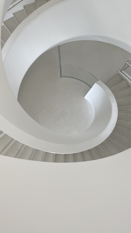 a spiral staircase in a building with a skylight