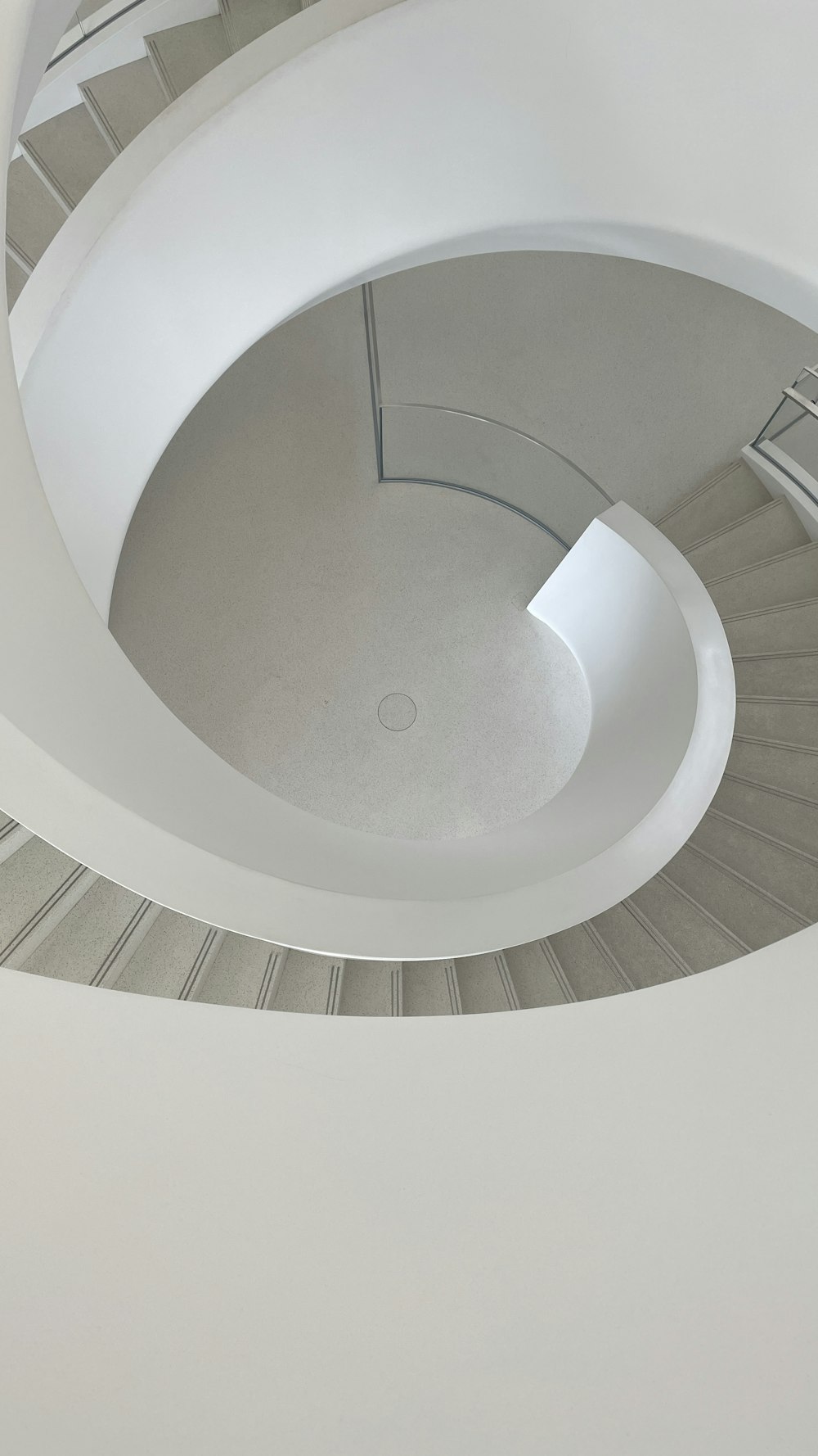 a spiral staircase in a building with a skylight