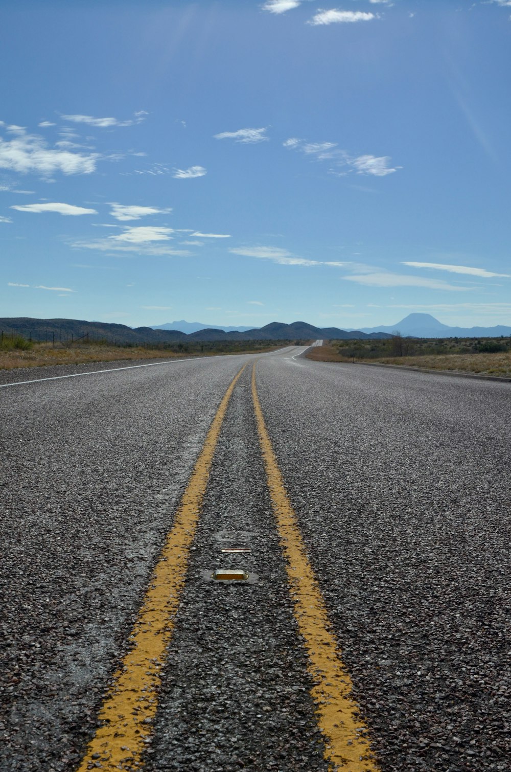 an empty road with a yellow line on the middle of it