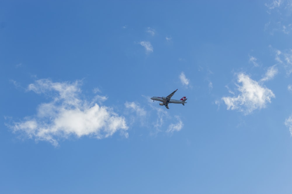 an airplane is flying in the blue sky