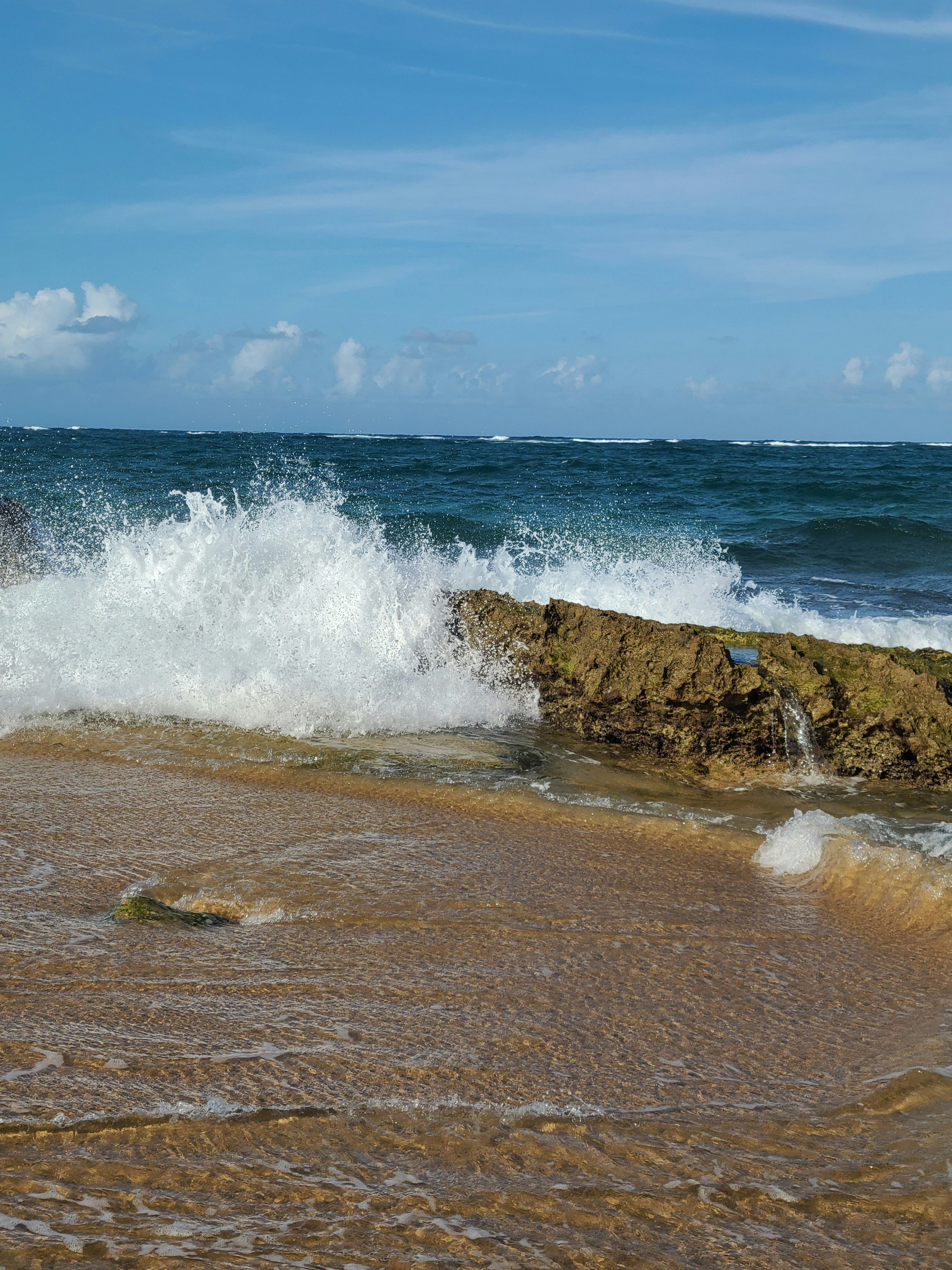 a wave crashes on a rock in the ocean