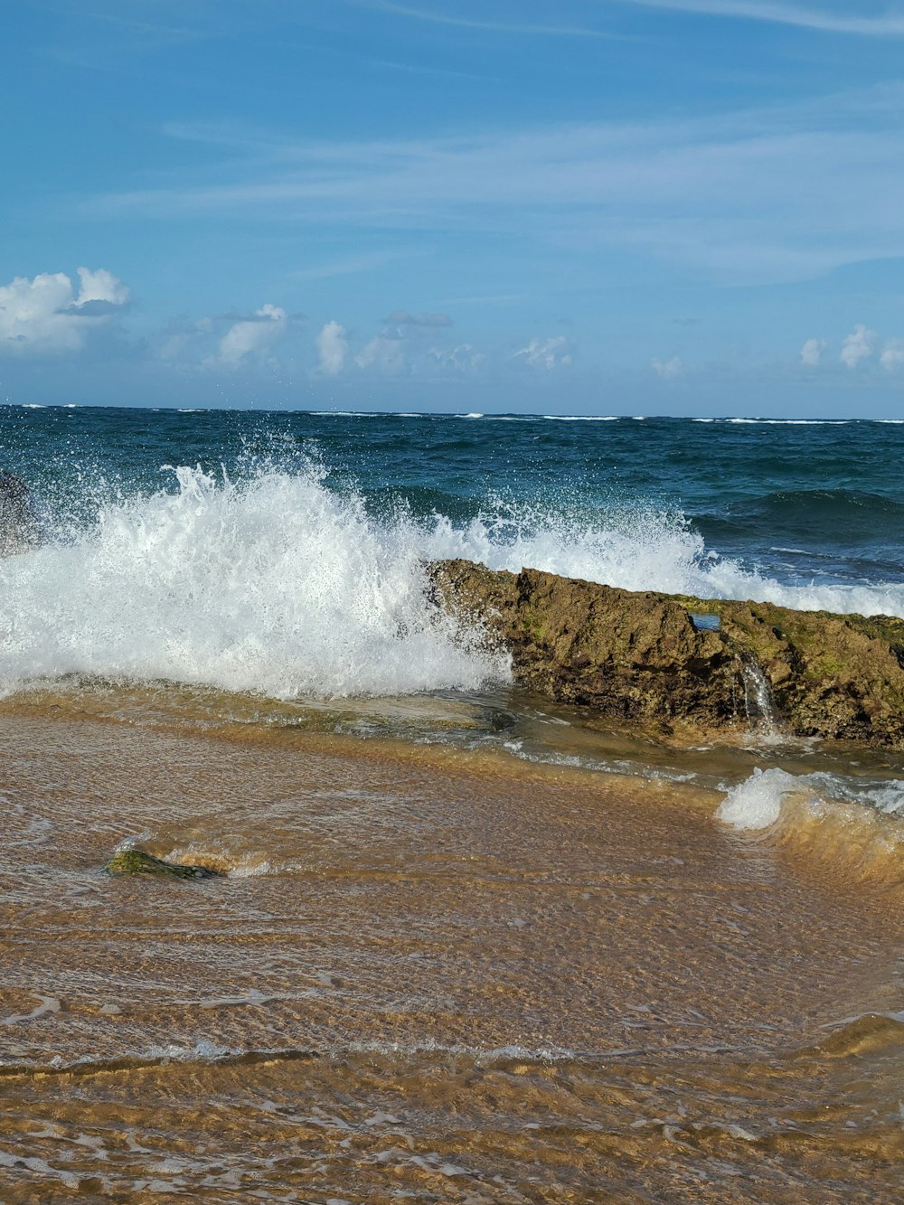 a wave crashes on a rock in the ocean