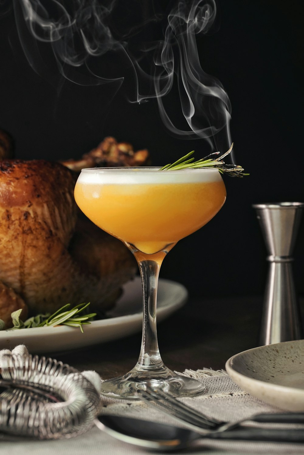 a glass filled with liquid next to a plate of food