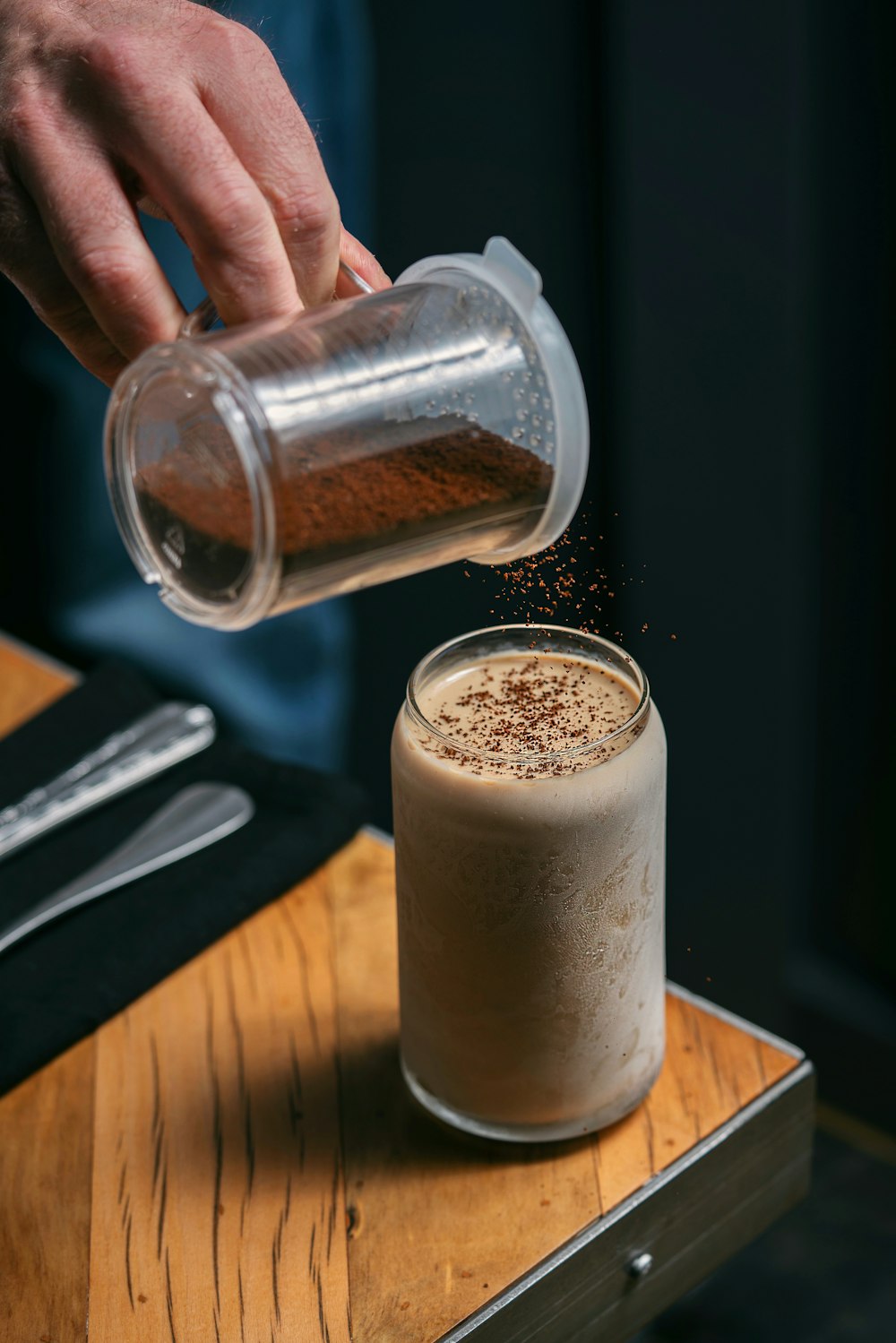 a person pouring a drink into a glass