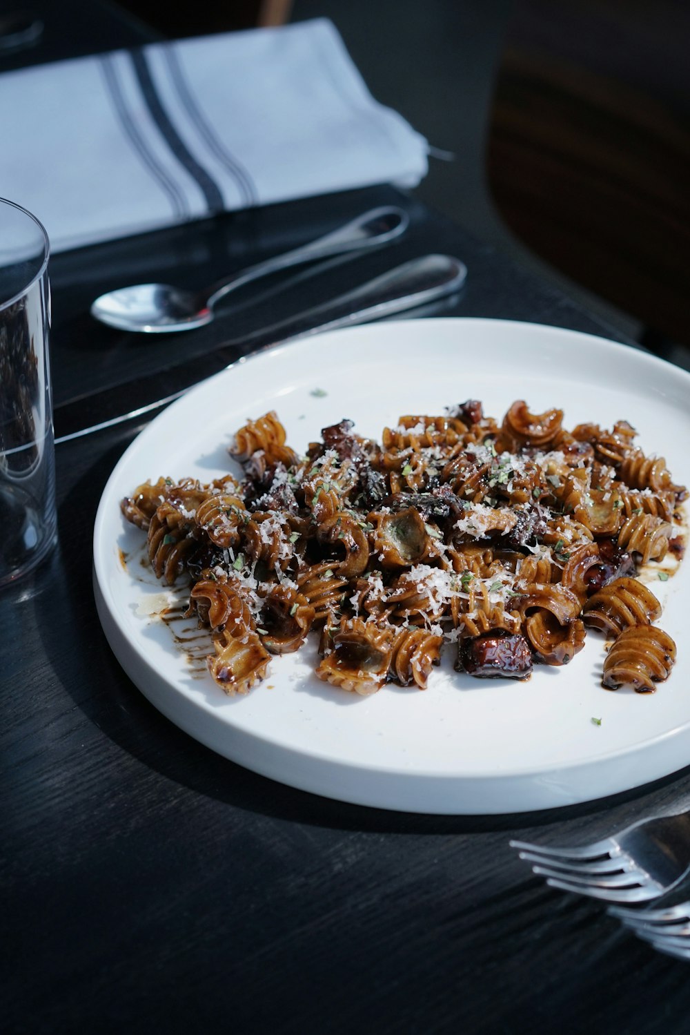 a white plate topped with pasta and meat