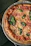 Close-up of a freshly baked Margherita pizza with bubbling cheese and fresh basil leaves.