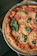 Close-up of a piping hot Margherita pizza with bubbling cheese and basil leaves.