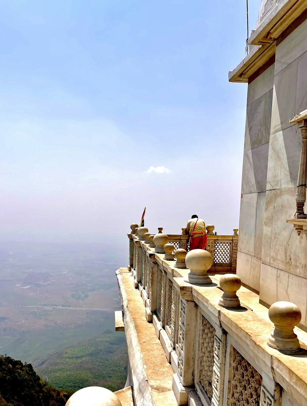 a person standing on a ledge of a building