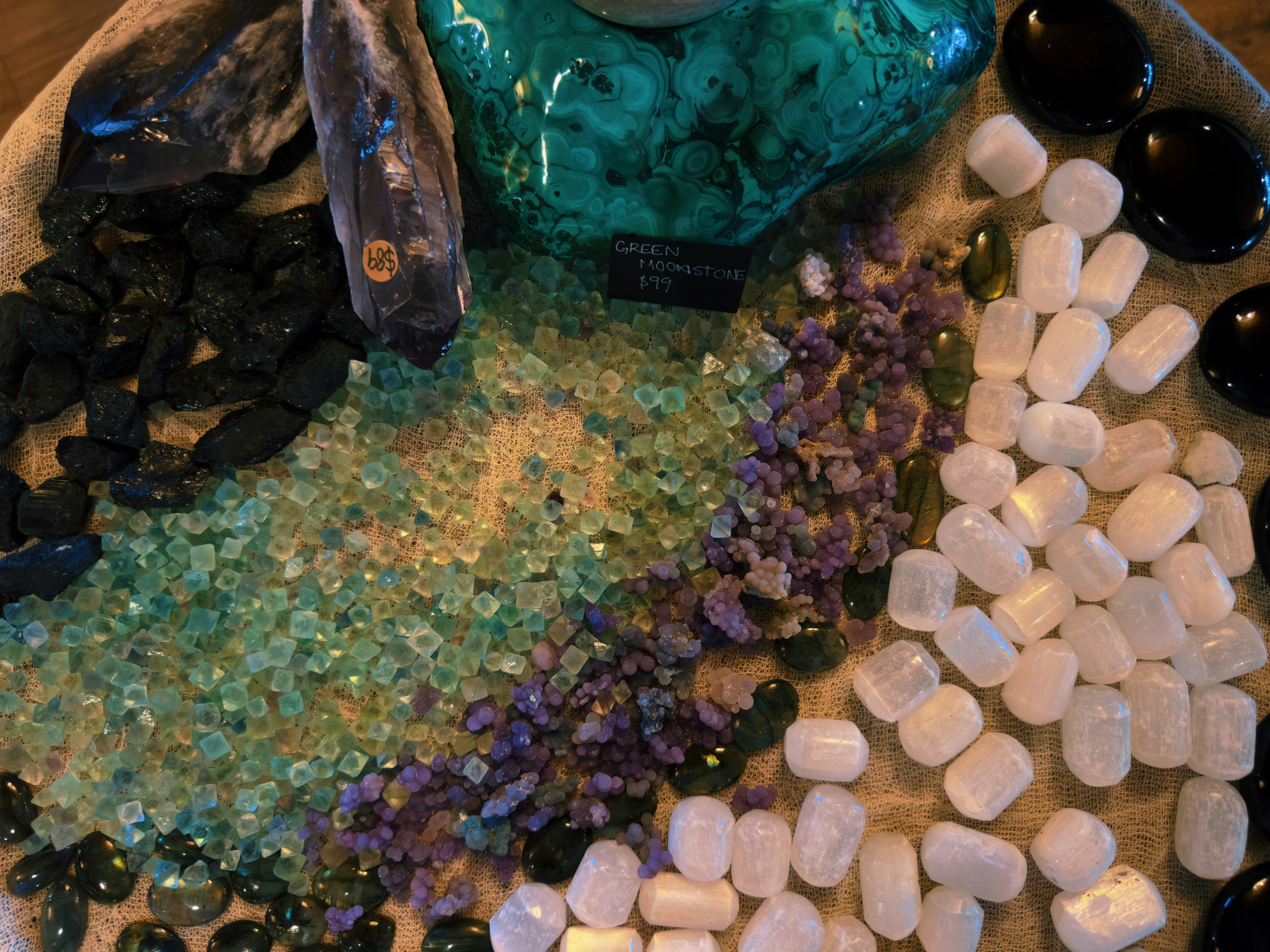 Raw and polished crystals arranged on a burlap surface.