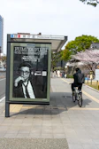 A professional advertising campaign poster mounted on a city bus stop.