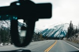 A scenic view of a car driving through the mountains.