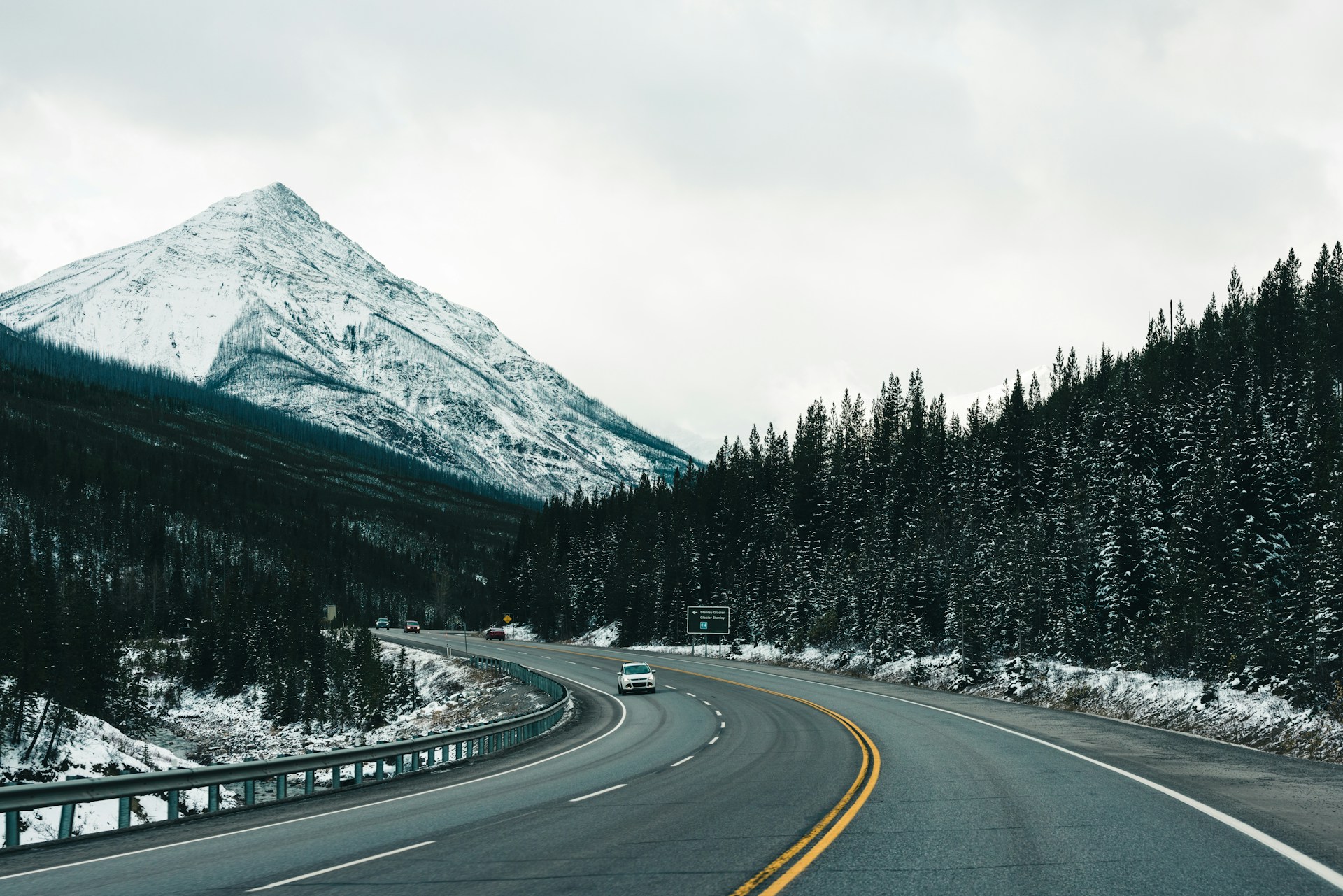 a car driving down a road with a mountain in the background