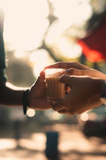 A close-up of hands exchanging ideas over coffee, reflecting the personal development focus of Brave Arunachal Consultancy.