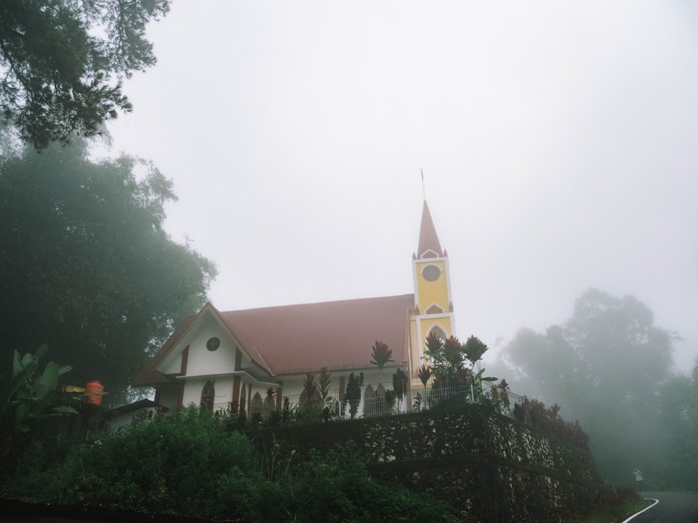 a church with a steeple on a foggy day