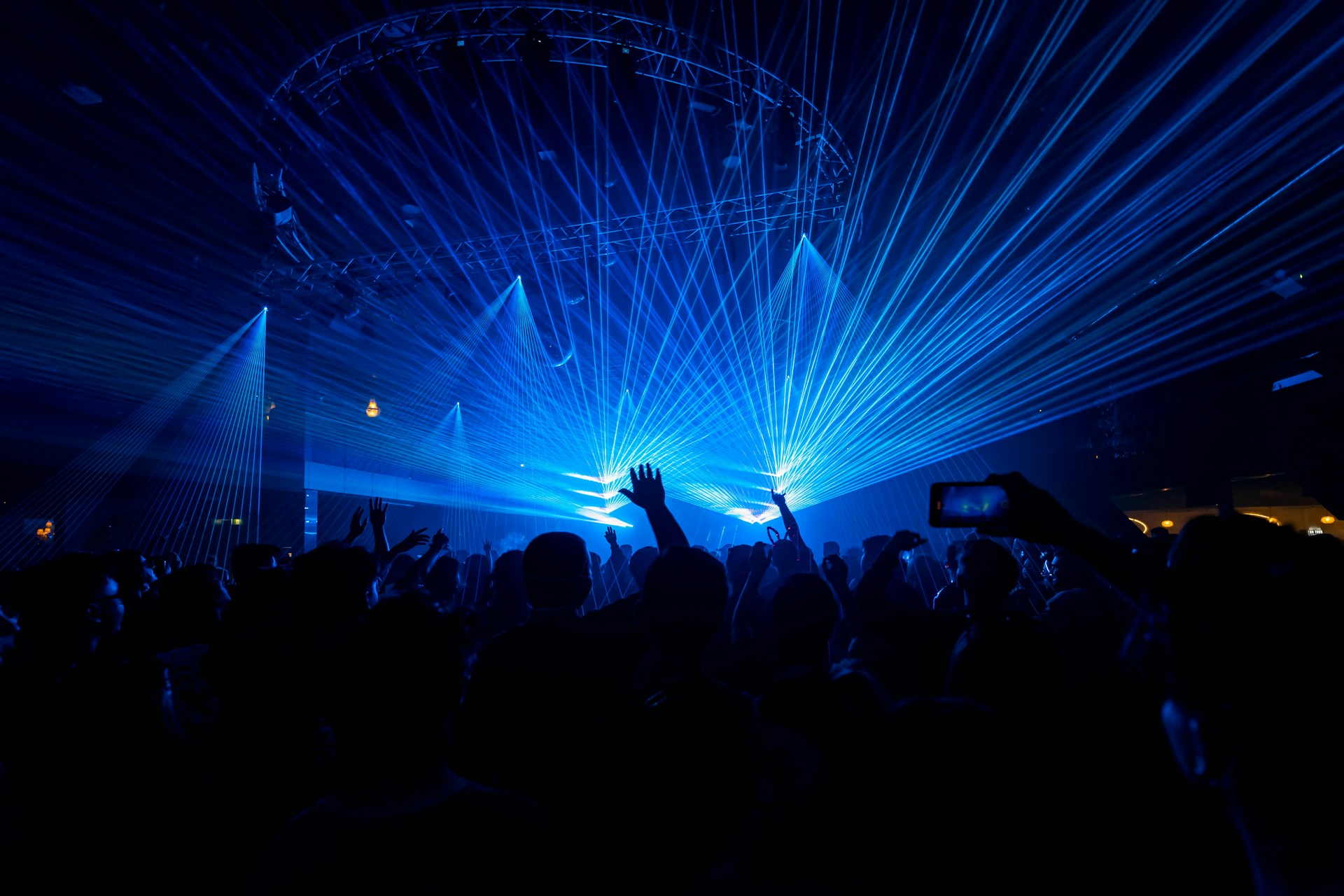 a crowd of people at a concert with their hands in the air