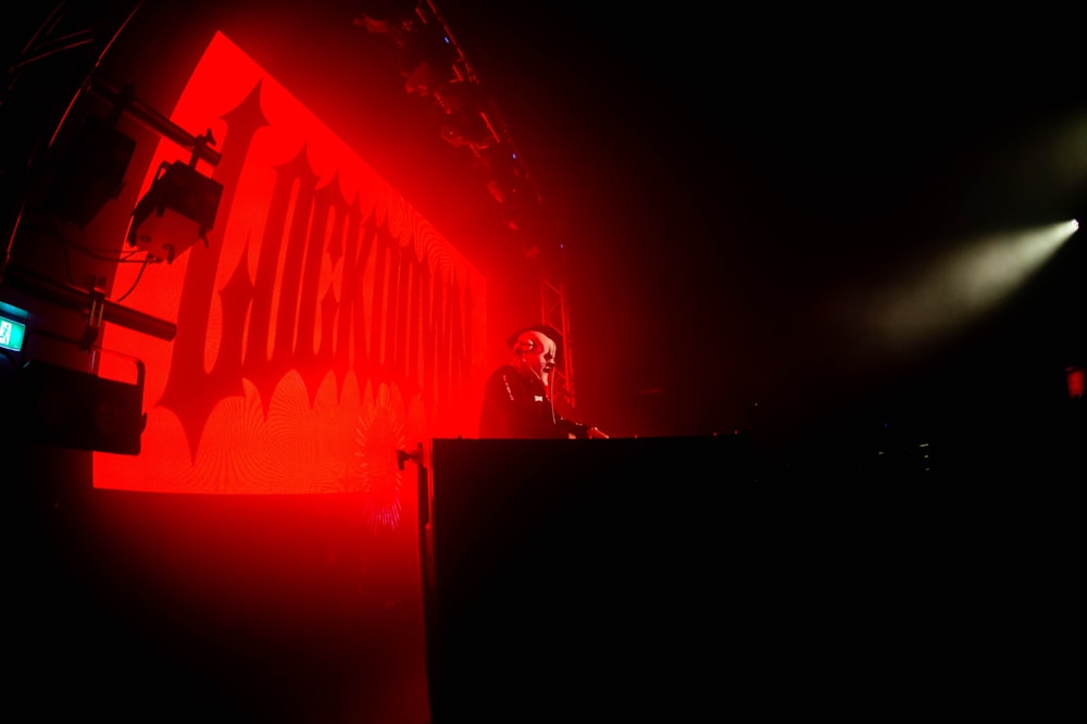 a man standing on a stage in front of a red light