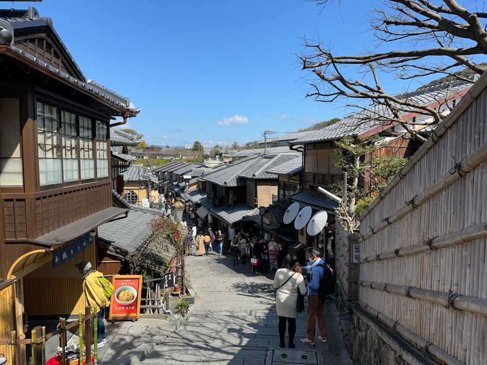 a group of people walking down a street next to buildings