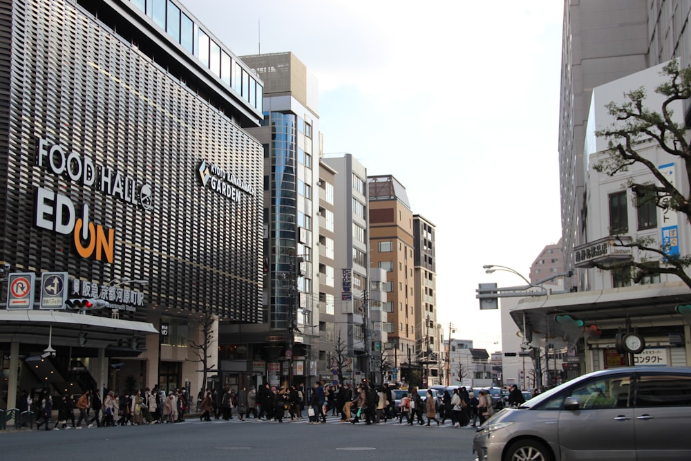 a crowd of people walking down a street next to tall buildings