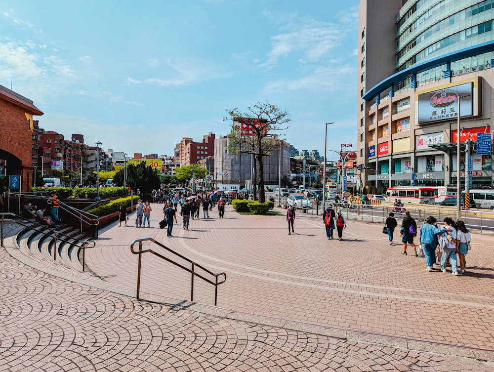 a group of people walking down a street next to tall buildings