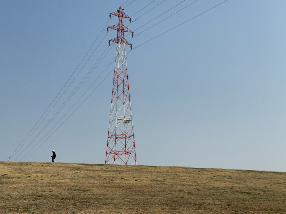 a man standing on top of a grass covered hillside