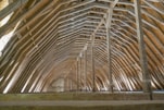 the inside of a building with wooden beams