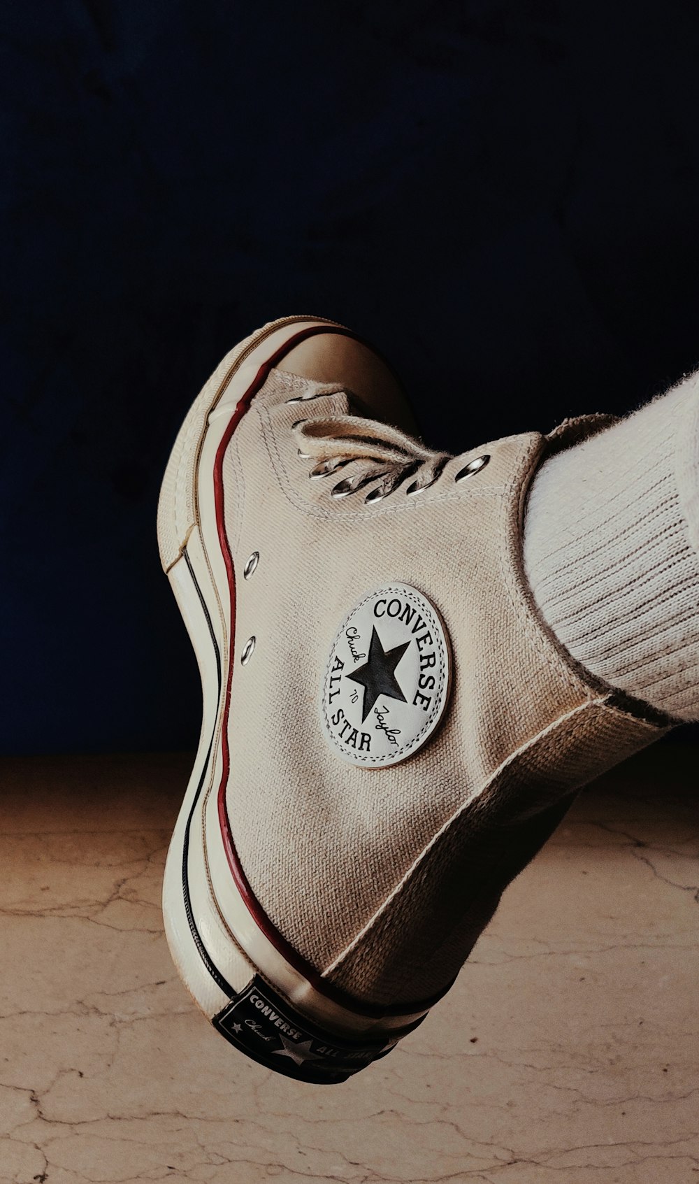 a person's feet with a white converse shoe