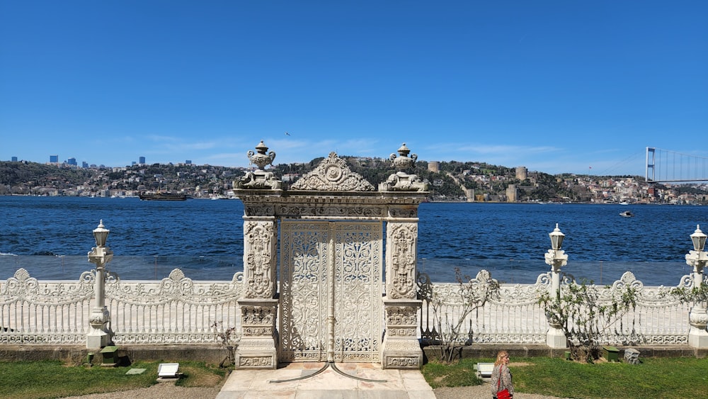 a large white gate sitting next to a body of water